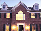 daily Devotion two story brick house with black shutters and two dormers