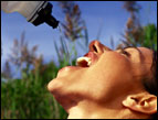 girl quenching thirst by squirting water bottle in her mouth