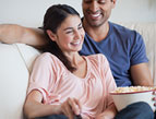 Couple eating popcorn, watching a movie