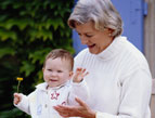 grandmother, baby in grandmother's lap smiling baby, baby waving hi