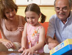 grandchild and grandparents doing puzzle