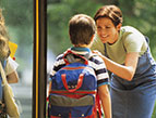 mother sending son off on the school bus