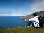 man meditating on a hillside