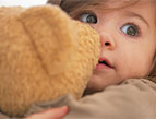 toddler cuddling with stuffed animal toy